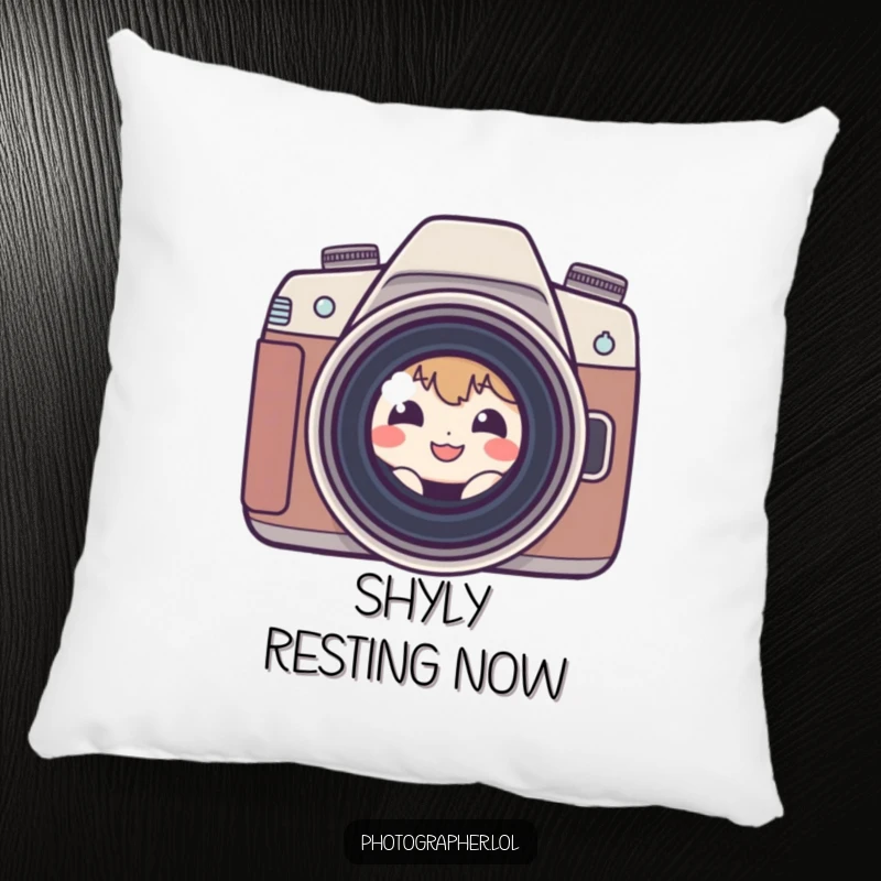 Funny shy photographer pillow with a small, grinning character peeking from behind a camera lens, adding a humorous touch.