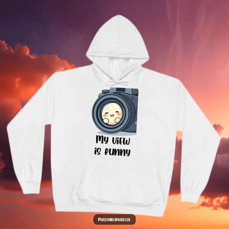 Funny, cozy hoodie depicting a cute blob character giggling while looking through a vintage camera lens, radiating warmth and humorous charm.